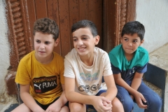 Three local young boys enjoying the morning just hanging out.