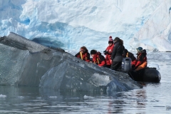 A group from our ship looking at an over turned iceberg.