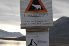 Sign warning everyone not to venture beyond it without a weapon to defend against Polar Bears.