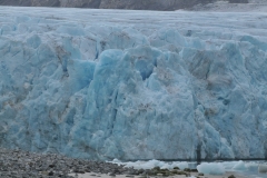 The release of blue light comes from the sunlight. As the ice is transparent, it permits light to pass through. Before the ice allows light to pass through it, the ice crystals absorb light of longer wavelengths from the visible spectrum.