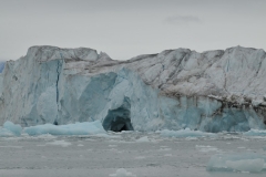 An area of the glacier has broken off to form what looks like an entrance to a cave.  This area could collapse at an time cause a calving of the ice and a small tsunami of water away from the glacier. A dangerous area to be too close to it.