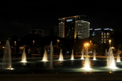 Illuminated  buildings in the background with multiple fountains in the foreground. Beautiful in the evening to see.