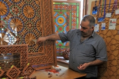 A local artisan demonstrates for us the art of making Shebeke Mosaic colored glass set in wooden lattice.