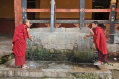 Two young Monks, young boys, in training brushing their teeth from the water faucet