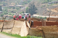 Women in Bhutan working hard building a home