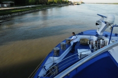 Deck hand getting to through a line to tie up at the dock along the river Danube.