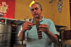 Showing us how the cork is cut out of each piece of bark of the cork