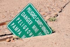 Danger mine field.   The high desert sand claims everything including signs warning of danger.