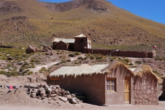 Small church of Machuca and village. Roofs of homes made from native vegetation.