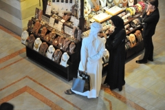 She shops, he pays and holds the goods. Same around the world
