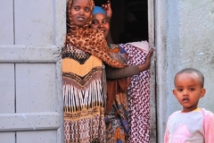 Young mothers looking out the door of their home inside the Market.