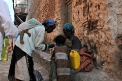 I thought this was an interesting photo two mothers looking at something very important with a baby asleep on the back of one with the little girl looking on too.