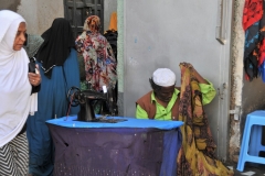 Tailors working on their sewing machines on the cobbled street..