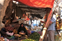 Selling vegetables. Notice the old scale for weighing the items.