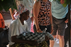 A young mother sharing her new borne with the ladies int he group.