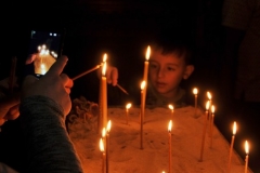 Young boy lights a candle