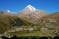 Surrounded by gigantic mountains  the town of Kazbegi is a picturesque settlement .   The town and surrounding rugged area provide some of the most picturesque scenes in Georgia.