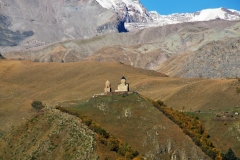 A telephoto look at Gergeti Trinity Church across the valley on the mountainside.