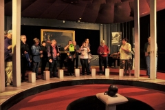 A small entrance leads to the next room where Stalin’s death mask is displayed in the center of a circle surrounded by pillars. The room is kept dark and painted black with dark red carpet, creating an atmosphere that is similar to the Lenin Mausoleum.