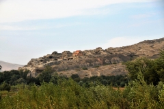 Uplistsikhe  "the lord's fortress" is an ancient rock-hewn town in eastern Georgia, some 6 miles east of the town of Gori.  Built on a high rocky left bank of the Mtkvari River, it contains various structures dating from the Early Iron Age to the Late Middle Ages, and is notable for the unique combination of various styles of rock-cut cultures from Anatolia and Iran, as well as the co-existence of pagan and Christian architecture.
