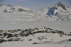 A photo of Tasiilaq in the winter with the bay frozen over.