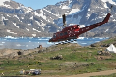 Leaving the Kulusuk air pad out and over the bay and then up into the air over the surrounding mountains.