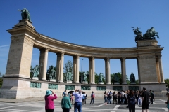 Statues of kings and other important historical figures stand on top of the colonnades on either side of the center pillar.