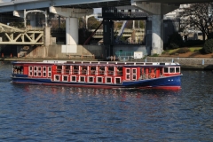 Tourist boat on the Sumida River in front of the Asahi Headquarters.