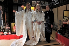 Marta Hall left and Leslee Gaul center model the wedding dress of Shimizu Sanami right that she brought to share with the ladies inside the home of Yamadason.