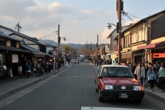 Notice the taxi cab driver in the forground. Each driver wears white gloves driving and a coat and tie. The seats have lace over the covers in many instances. The insides are impeccably clean. Lots of people walking in town in the early evening hours.