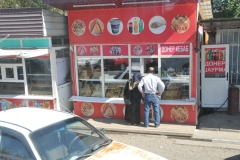 A couple looking in the window of a local bakery probably trying to decide what to take home tonight.
