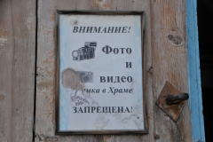 Sign that has to be old showing a camera inside the church.