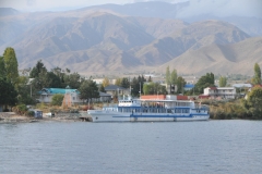 Cholpon-Ata is a resort town on the northern shore of Lake Issyk-Kul in Kyrgyzstan with a population of 14,237.  It is the administrative center of the Issyk-Kul District. This district occupies most of the lake's north shore. The town contains numerous large and small  hotels and guesthouses to accommodate the many visitors who descend upon the lake in summer. During the Soviet era it was much frequented by vacationers brought here in organized mass tours from other parts of the USSR. A second ship leaving shore with tourists on board to enjoy the sunset on the lake.