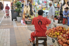 The men in the orange jump suits are there to help you with your shopping in the food market. For a fee they push the carts while you shop for food.