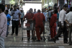 They are waiting for shoppers to come into the food market. They will push your groceries until your cart is full for a fee.