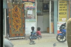 Young boys sitting in front of a money changing business.