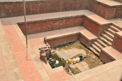 Public wells have pots lines up waiting to recieve the water for the residentes