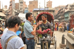 To the left in the photo is our guide in Nepal Binoy Rai negotiating for Rickshaw rides for our group of 9 .
