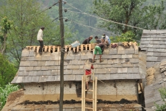 Working on a roof nearby. Notice they are working on the roof in sandals..