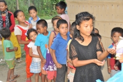 Waiting in line for Binoy to give each of them a piece of candy