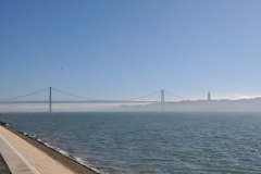 The northern bank of the Tagus river with the 25th de Abril Bridge spanning the river in the distance.  The monument is located along the river where ships departed to explore and trade with India and the Orient, the monument celebrates the Portuguese Age of Discovery, "Age of Exploration", during the 15th and 16th centuries.