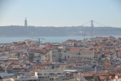 In the distance is the Cristo Rei Lisbon, next to the 25 de Abril Bridge. The Lisbon statue of Christ the King stands facing the city with open arms in the form of a cross on a 435-foot bluff on the left bank of the Tagus River.