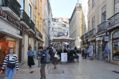 Shops on both sides of the walking street with outdoor seating in restaurants as you walk the Chiado area.