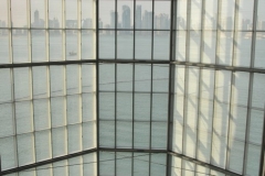 Looking through the multi story glass lobby seeing the city of Doha across the bay