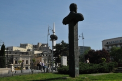 Statue in the foreground is of Corneliu Coposu at Revolution Square. The second square is  referred to as the Baked Potato.  I agree.