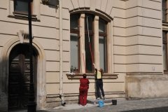 Two women washing windows. I am not sure if they have invented ladders here yet.