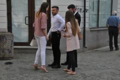 Two couples standing on a corner talking.