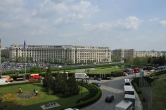 Views in all directions of buildings and parked cars.