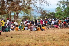 This is a community meeting alongside a road outside of Kigali. Everyone in each area is required to attend these or have a representative from each house to learn what is happening in their areas.