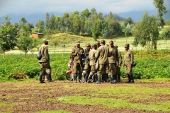 A group of Porters waiting to be assigned to climbers.  Each person is assigned a Porter from this elevation around 4,000  feet climbing to 7,000 feet.  From 7,000 each person is assssigned  a Trekker with one hand on your hand and the other with a Machete in hand to clear the underbrush and lead you to the gorillas. at around 10,000 foot elevation.